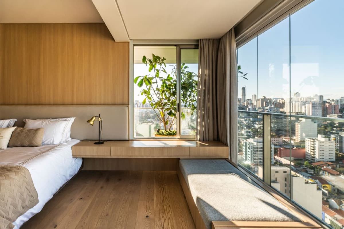 Spacious serviced apartment bedroom with a built-in desk and large window