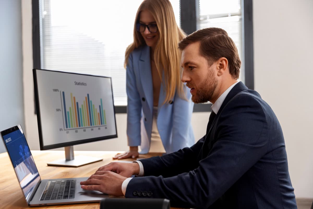 Project managers reviewing contractor stay reports on a computer