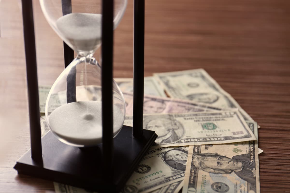Hourglass on currency symbolizing efficient travel procurement