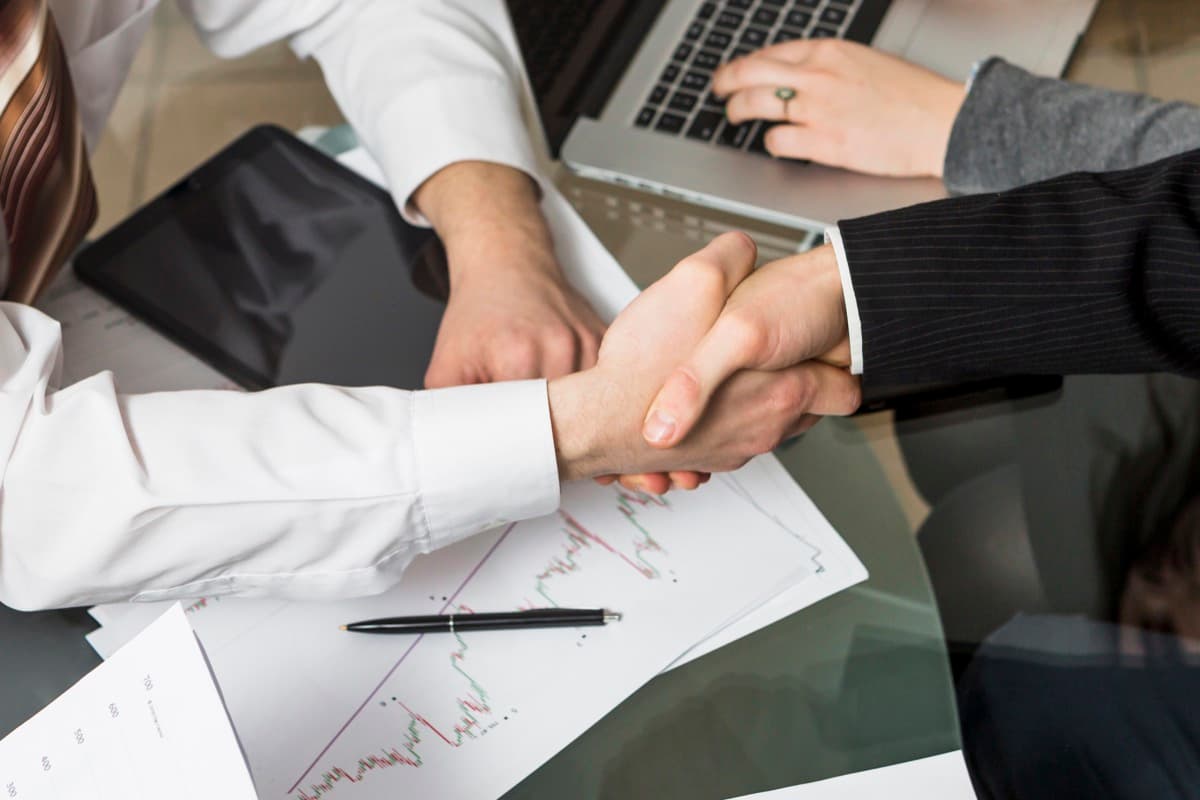 Business professionals shaking hands over a corporate accommodation agreement