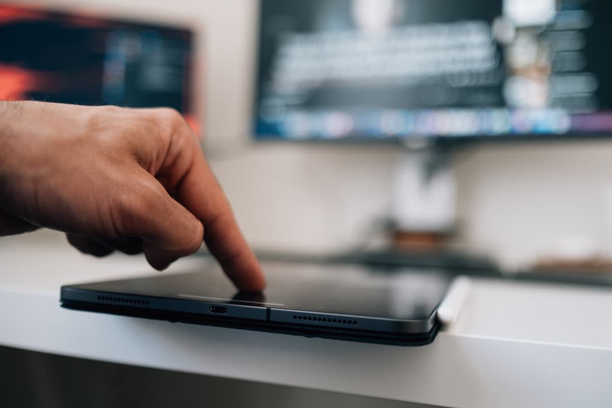 Hand using a tablet to manage corporate accommodation bookings