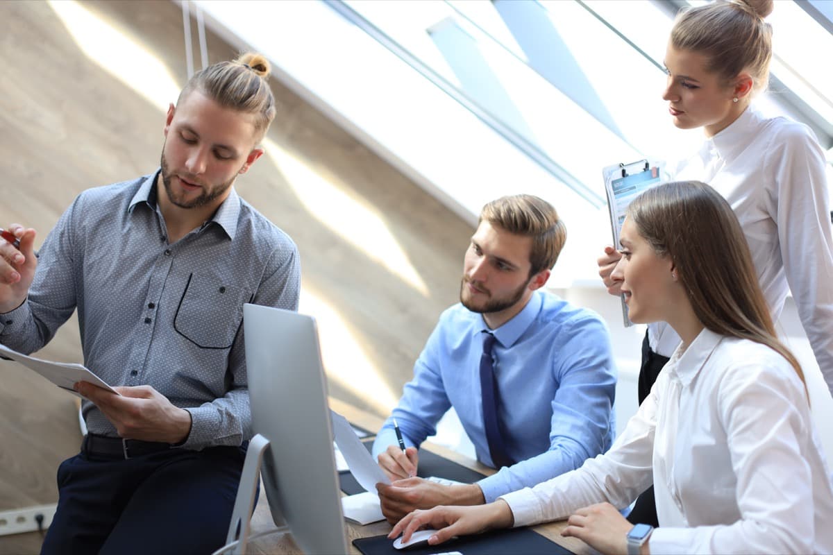 HR and mobility team reviewing relocation reports on a laptop