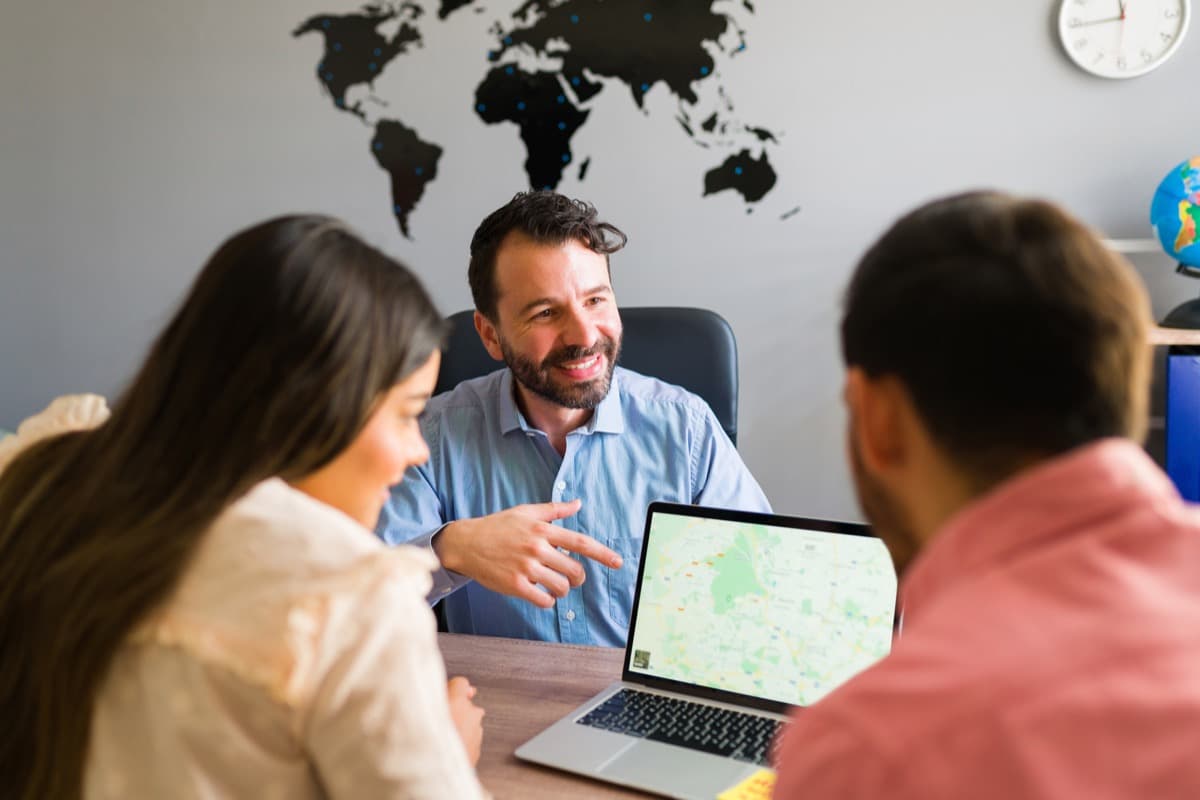 Travel professionals reviewing family booking reports on a laptop