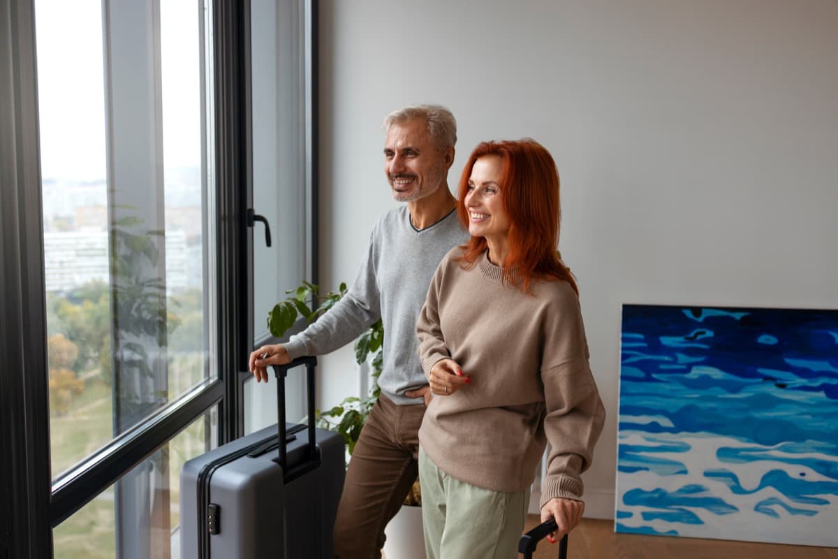 Couple with luggage entering a bright, professionally managed holiday apartment