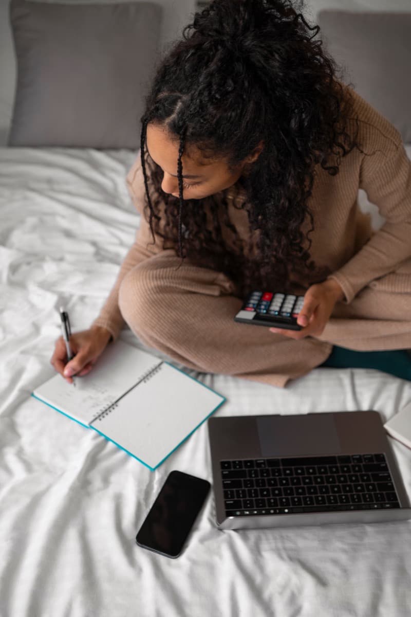HR professional tracking relocation accommodation budgets on a laptop with a calculator