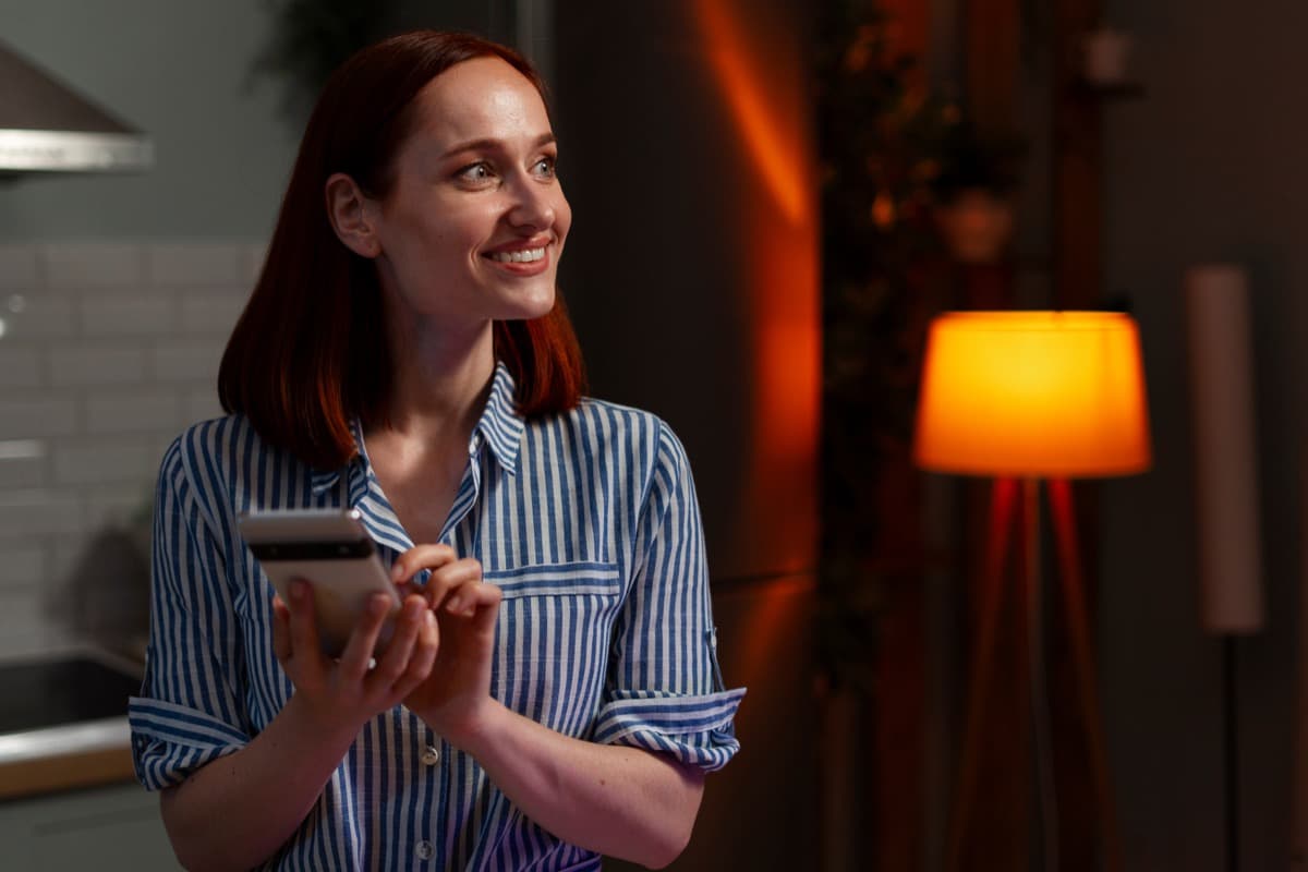 Individual managing bookings on a smartphone in a warm evening setting