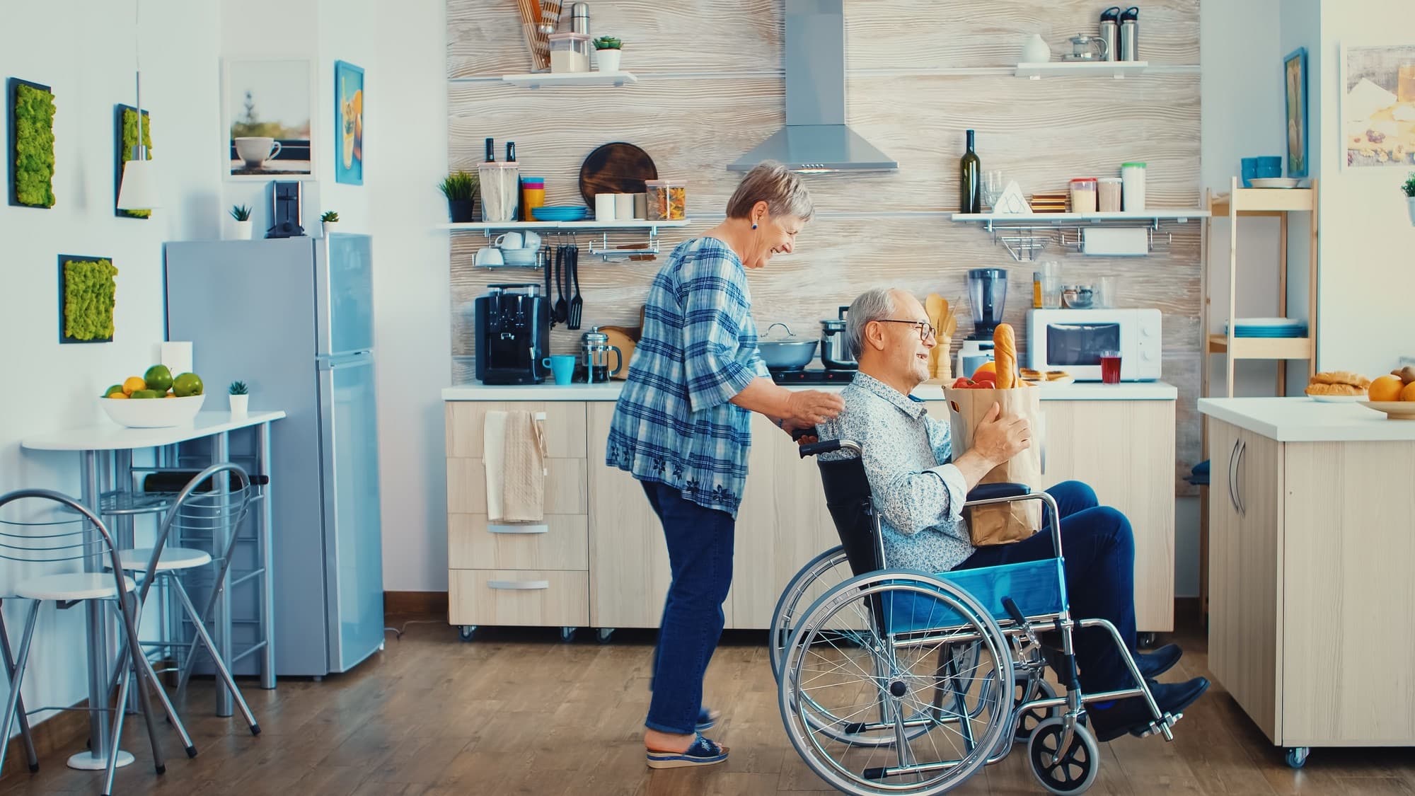 Caregiver assisting a patient in wheelchair in accessible medical stay accommodation