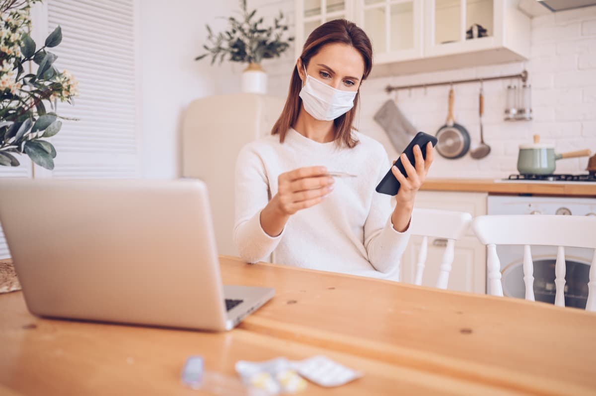 Patient using a laptop while monitoring health at home during a medical stay